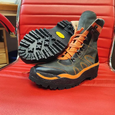 Maßgefertigter Outdoorstiefel mit grober Profilsohle und orangen Schnürsenkeln
